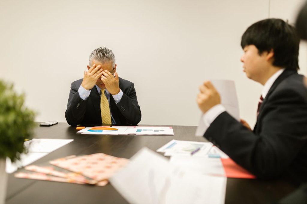 売却価格の計算結果を前に考える経営者