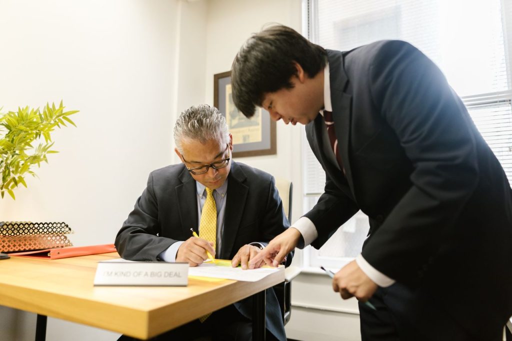 後継者に書類を引き継ぐ経営者